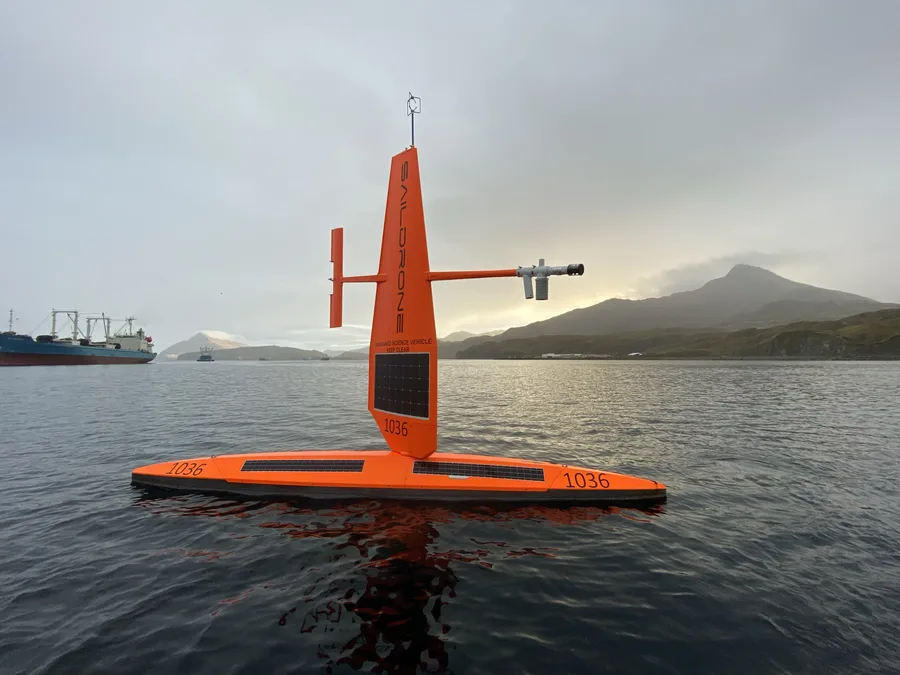 A Saildrone unmanned surface vehicle floating near a harbor in the Aleutian Islands, Alaska