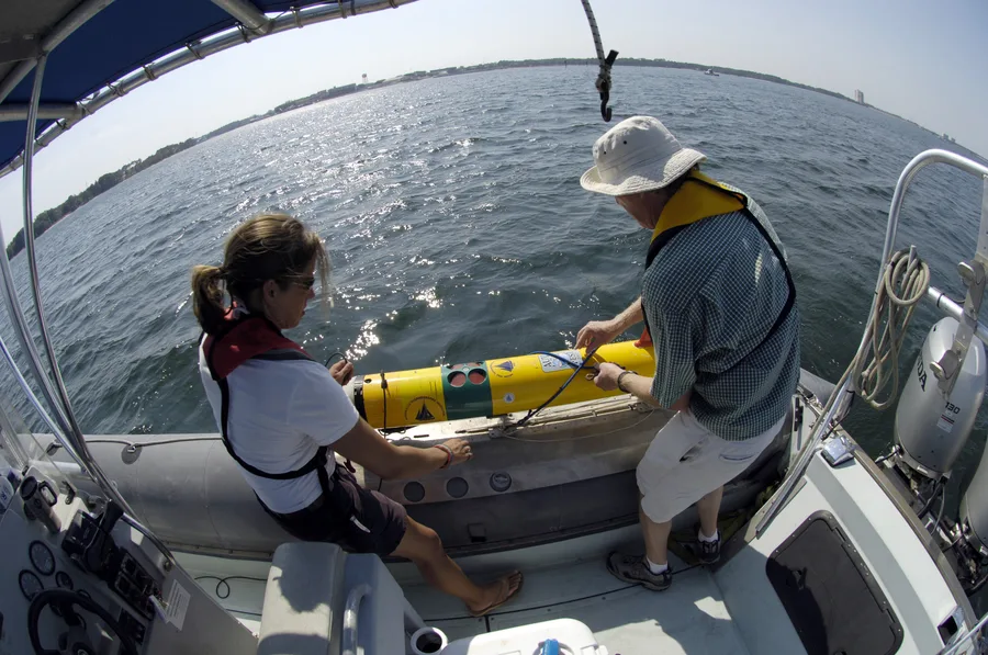Researchers preparing to launch a REMUS autonomous underwater vehicle from a small boat