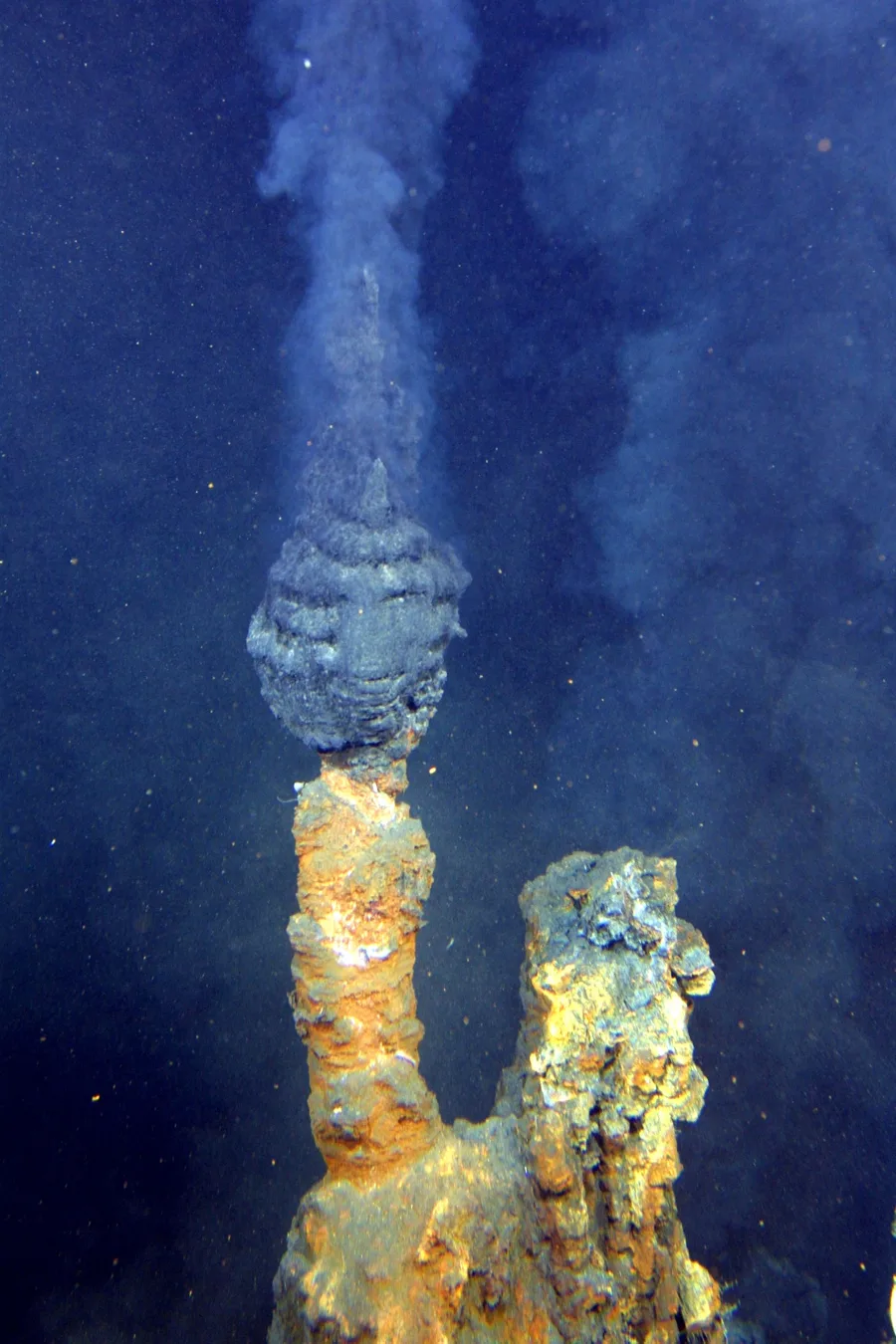 A black smoker hydrothermal vent releasing dark, mineral-laden fluid on the seafloor