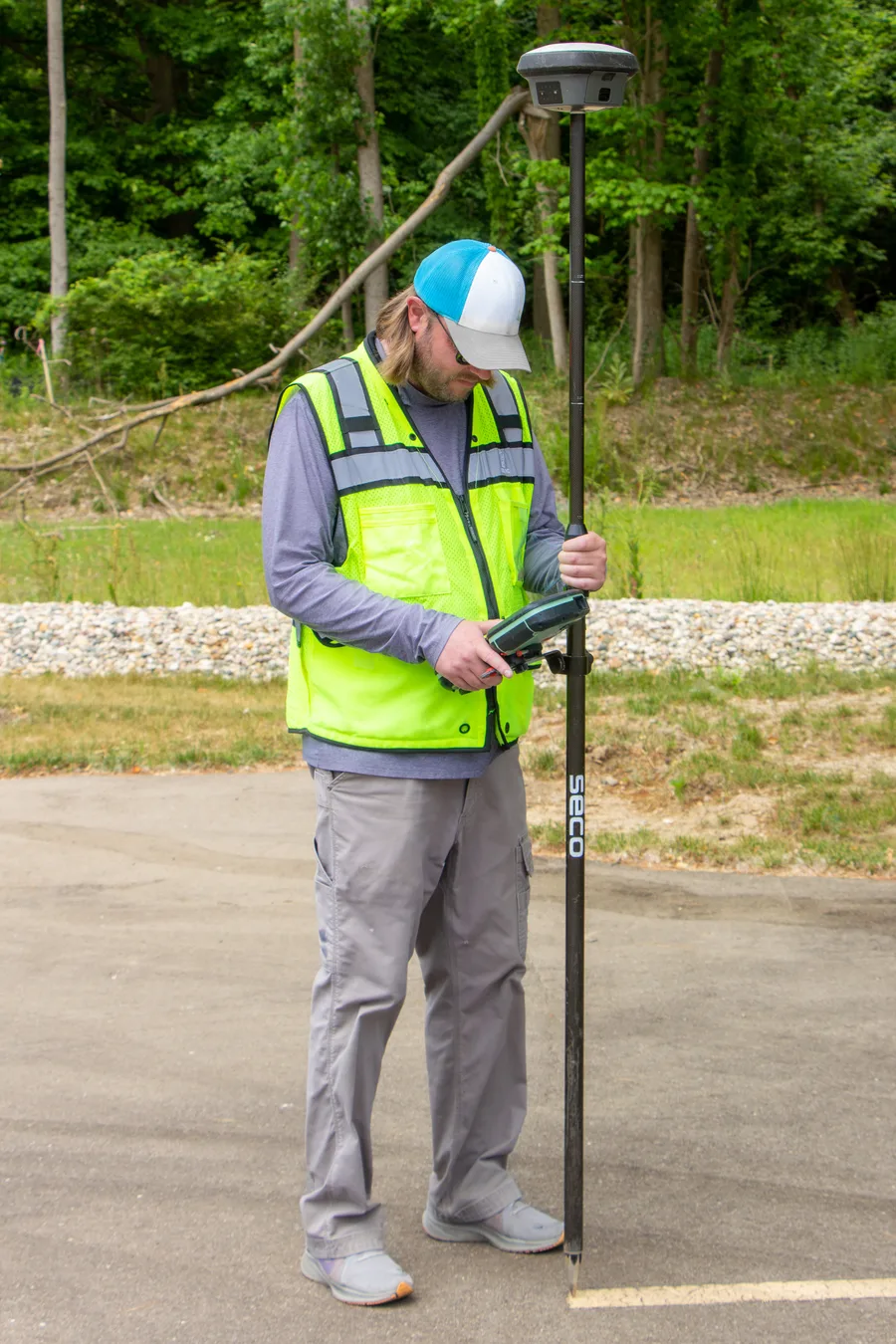 A surveyor using a GNSS receiver with an RTK solution mounted on a pole